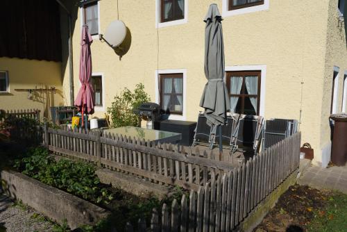 a fence with umbrellas and chairs in front of a building at Private Farmhouse Escape - Ideal for up to 8 Guests in Seeham