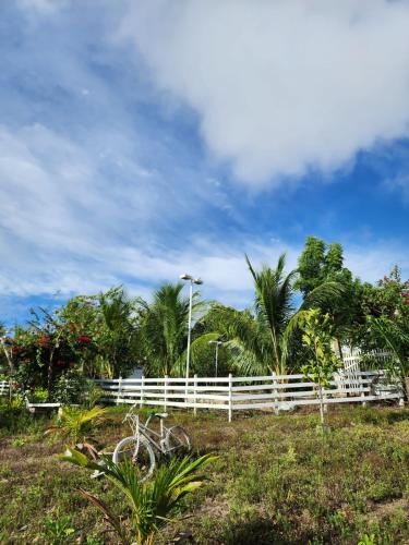 ein Fahrrad, das auf einem Feld neben einem weißen Zaun parkt in der Unterkunft Sitio Nyssa in Campo do Brito