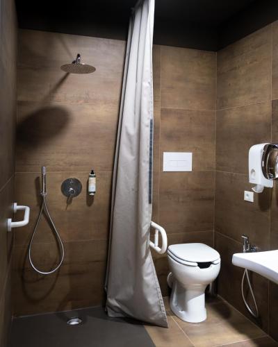 a bathroom with a shower with a toilet and a sink at Hostelò - Luxury Hostel in Palermo