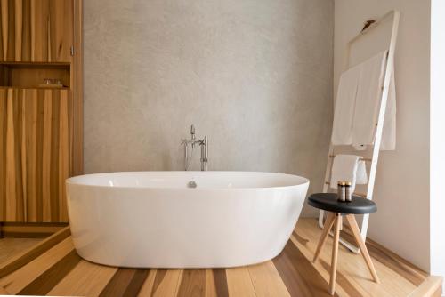 een badkamer met een wit bad en een tafel bij Palau Sa Font in Palma de Mallorca