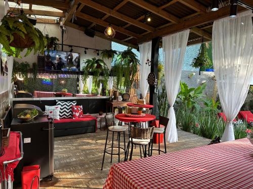 um restaurante com mesas vermelhas e cadeiras num quarto em UFSC Guest House em Florianópolis