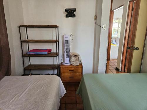 Cette chambre dispose de deux lits et d'un radiateur sur une table. dans l'établissement CHALET EN PUERTO VIEJO IZTAPA, à Escuintla