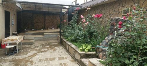 a garden with flowers and plants on the side of a building at Gusar house for daily rent in Qusar