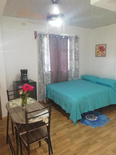 Un dormitorio con una cama y una mesa con un jarrón de flores. en Urbano y Económico, en David