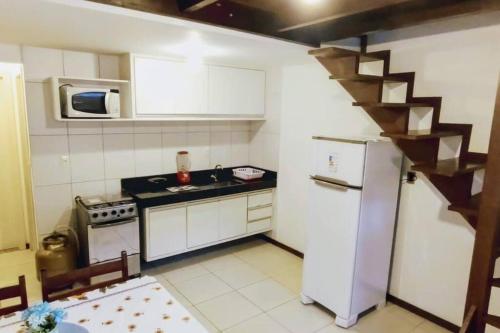 モロ・デ・サンパウロにあるEspaçoso apartamento a 50mt do marのシンクと冷蔵庫のある小さなキッチン