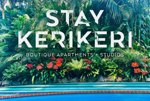a sign for a hotel with flowers and plants at Stay Kerikeri in Kerikeri