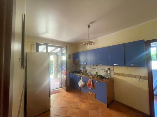 a kitchen with blue cabinets and a stainless steel refrigerator at Villa Hidra near Cefalù in Buonfornello