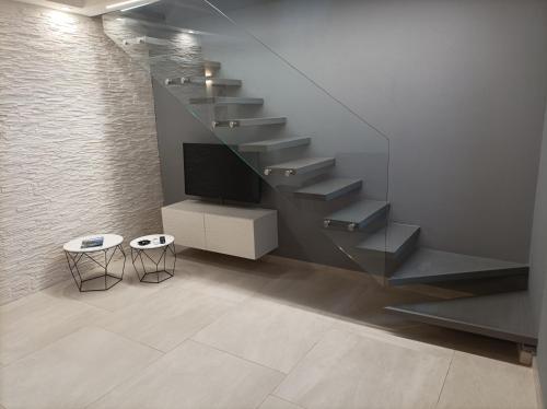uma sala de estar com uma escadaria com televisão e banco em CARLO'S Home em Catânia
