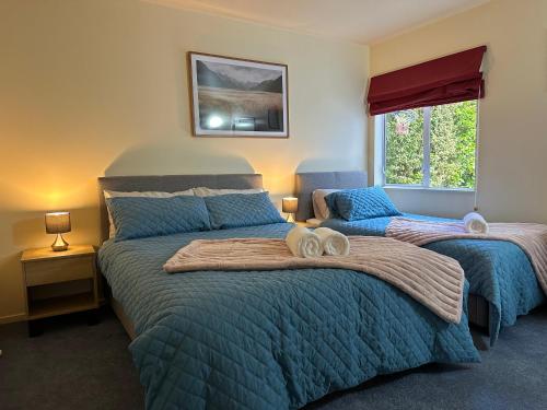 1 dormitorio con 2 camas y ventana en New Lynn Self- Contained Unit near Golf Course, en Auckland