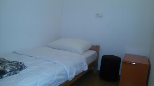 a bedroom with a bed and a night stand next to it at Motel Maks in Kiseljak