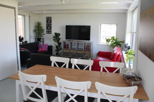 a living room with a table and chairs and a couch at vrijstaande ruime familiewoning landelijk gelegen in Lewedorp