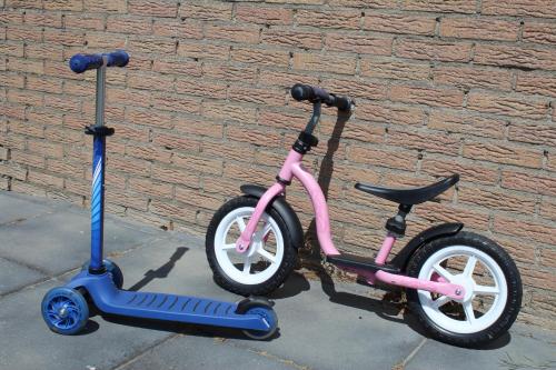 a pink and a blue scooter parked next to a brick wall at vrijstaande ruime familiewoning landelijk gelegen in Lewedorp