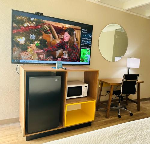 Habitación con TV, escritorio y microondas. en Days Inn by Wyndham Ocala North, en Ocala