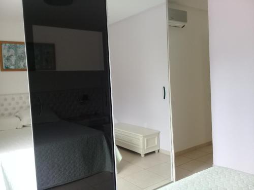 una camera da letto con specchio accanto a un letto di Suíte confortável para casal ou 2 mulheres a Balneário Camboriú