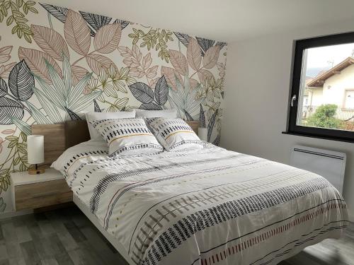 1 dormitorio con 1 cama y papel pintado con motivos florales en L'Escapade, en Bollwiller