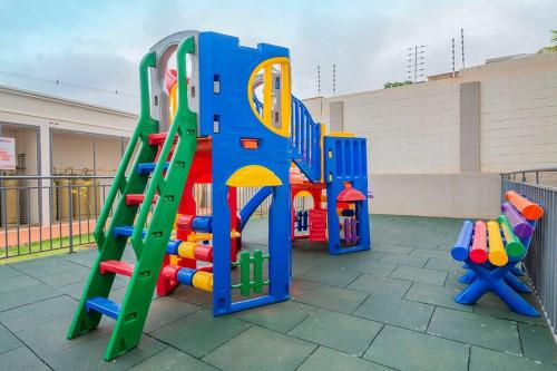 um parque infantil com um escorrega e um conjunto de jogos em Lagoa Da Prata - apt com piscina em Londrina