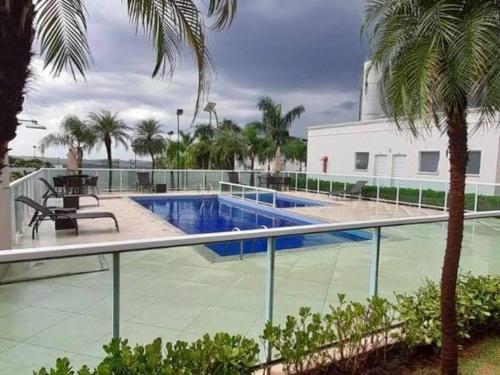 uma vista para uma piscina com palmeiras em Lagoa Da Prata - apt com piscina em Londrina
