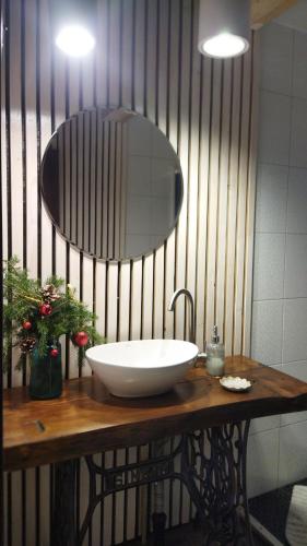 a bathroom with a sink and a mirror on a table at Захарова Оселя БАСЕЙН на території є Чан - Джакузі in Slavske