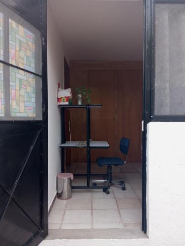 une chambre avec une chaise, une table et une porte dans l'établissement Sweet Room, à Tequisquiapan