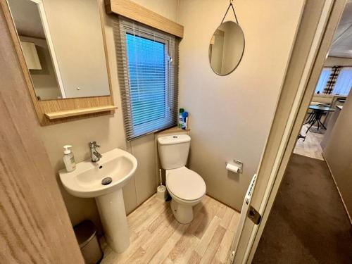 Un baño pequeño con inodoro y lavabo. en 2 Bedroom Lakeview Lodge - Ensuite & Balcony Deck, en Carnforth