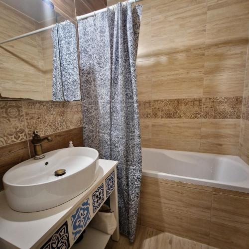a bathroom with a sink and a bath tub at Slnečná oáza pokoja in Partizánske