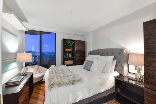 a bedroom with a large white bed and a desk at Skyview Executive Stay in Victoria