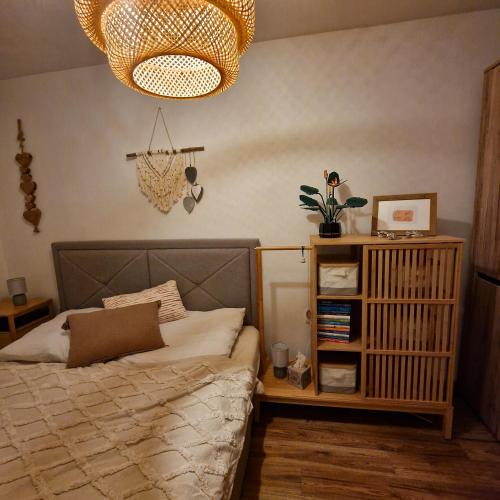 Schlafzimmer mit einem Bett und einem Kronleuchter in der Unterkunft Slnečná oáza pokoja in Partizánske