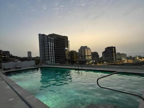 a swimming pool on top of a building with a city skyline at Apartamento en primera línea de playa in Puerto de la Cruz