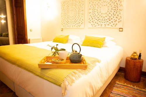 AR Country House في Cadaval: غرفة نوم مع سرير عليه صينية