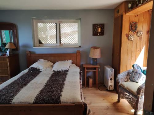 a bedroom with a bed and a chair and a window at Casa Isla Negra con hermosa vista al mar in Isla Negra