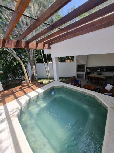 a swimming pool in a house with a roof at Casa Mar in Armacao dos Buzios