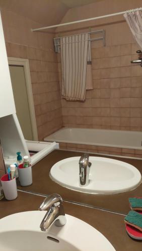 une salle de bain avec deux lavabos et un miroir dans l'établissement Appartement au pied de la Crémaillère Express, à Luchon