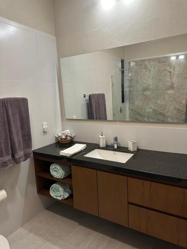 a bathroom with a sink and a large mirror at Oasis Urban Retreat in Cancún