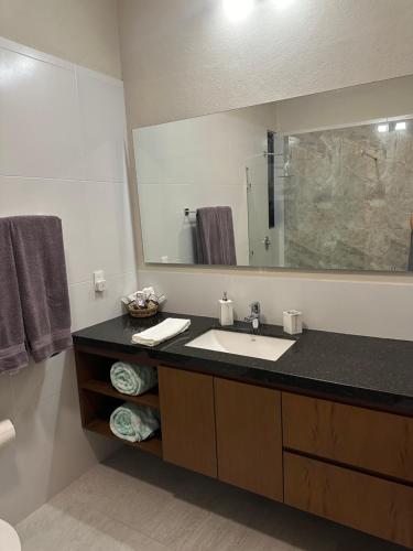 un baño con lavabo y espejo grande en Oasis Urban Retreat, en Cancún