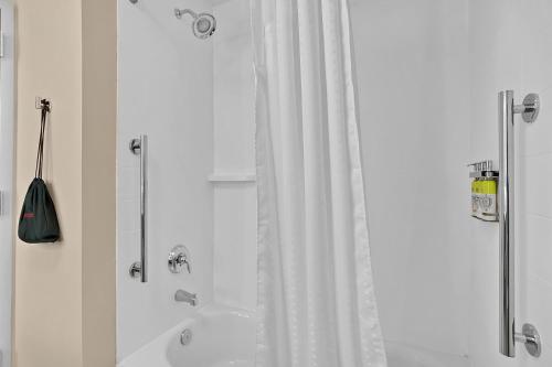 a bathroom with a shower and a tub and a sink at Holiday Inn Express - Jacksonville South Bartram Prk by IHG in Jacksonville