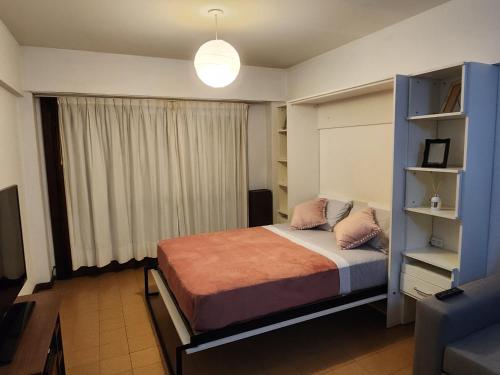 a bedroom with a bed and a blue shelf at LUAMAR 2-SAINT MICHELE in Mar del Plata
