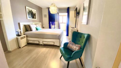 um quarto com uma cama e uma cadeira verde em Oasis in Los Cristianos By Deihu Experiences em Arona