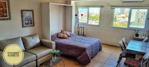 1 dormitorio con cama, sofá y ventanas en Departamento Allegretto Monoambiente en San Luis