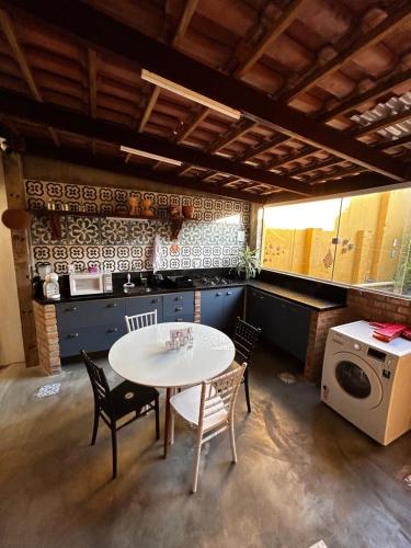 a kitchen with a table and chairs and a washer and dryer at Casarão 47 in Areia