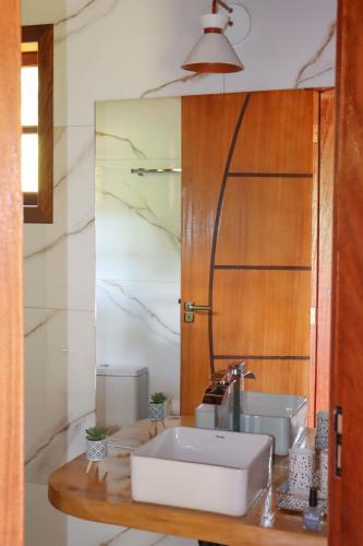 a bathroom with a sink and a mirror at Chalé Encanto da Natureza in Visconde De Maua