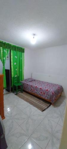 Bett in einem Zimmer mit grünen Vorhängen in der Unterkunft CASA AMPLIA TODOS LOS SERVICIOS in Mexiko-Stadt