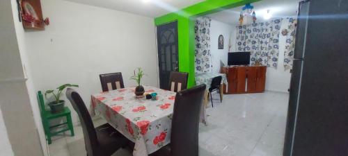 a dining room with a table and a green wall at CASA VIOLETAS a 20 minutos de aeropuerto AIFA in Mexico City