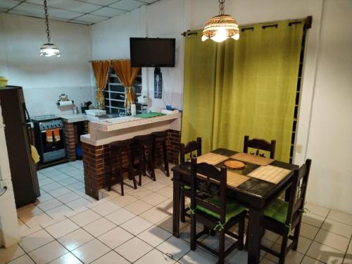 a dining room with a table and chairs and a kitchen at Granja Triple A in Guatemala