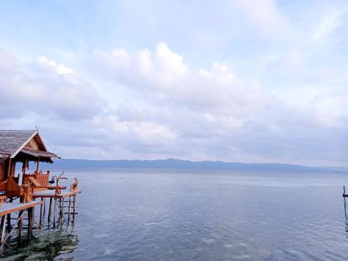 a large body of water with a house on a pier at Happy Homestay Arborek in Besir