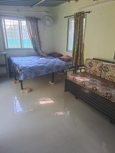 a bedroom with two beds and a couch at Private Farm Stay in Pune