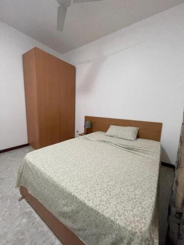 a bedroom with a large bed and a wooden cabinet at Isa House - Private Rooms in a Shared Duplex in Praia