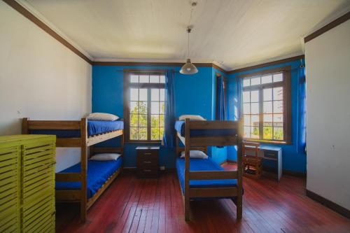 a room with three bunk beds and blue walls at Viña City Hostel II in Viña del Mar