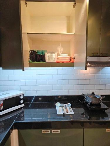 a kitchen with a counter top with a pot on a stove at Kai Lodge by the Hill 2 in Baguio