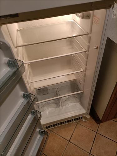 un réfrigérateur vide avec sa porte ouverte dans une cuisine dans l'établissement Maison sur 3 étages, proche de Disneyland, à Jouarre