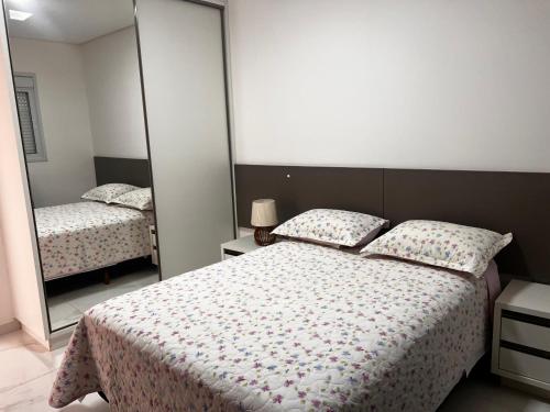 um quarto com uma cama e um espelho grande em Apartamento Ingleses para Casal 102 em Florianópolis
